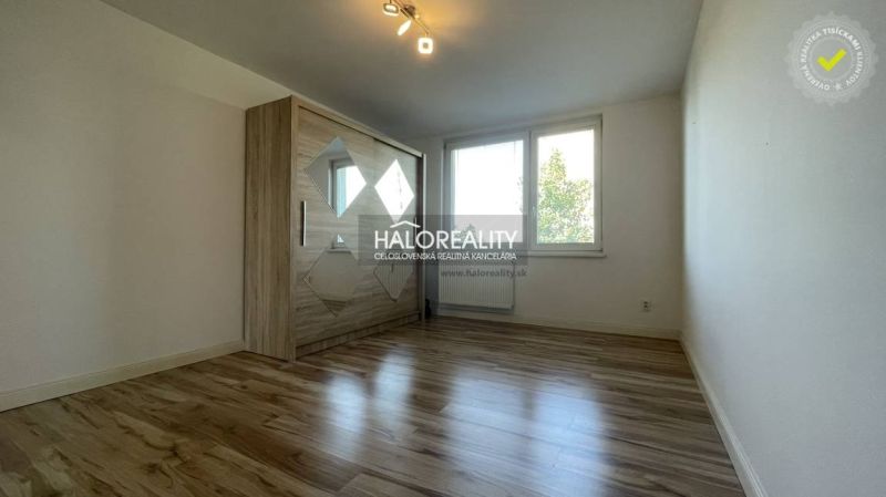 Helles Zimmer in einer 2-Zimmer-Wohnung mit Holzboden und Kleiderschrank.
