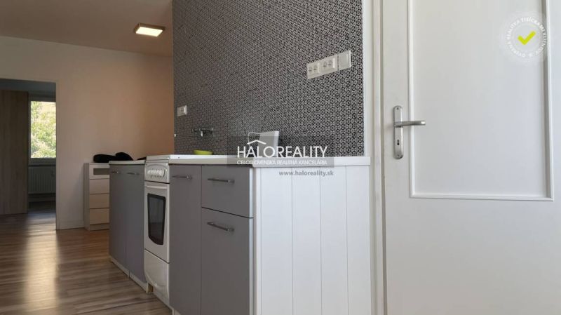 Eine Küche mit grauen Schränken und einem Holzboden in einer 2-Zimmer-Wohnung.