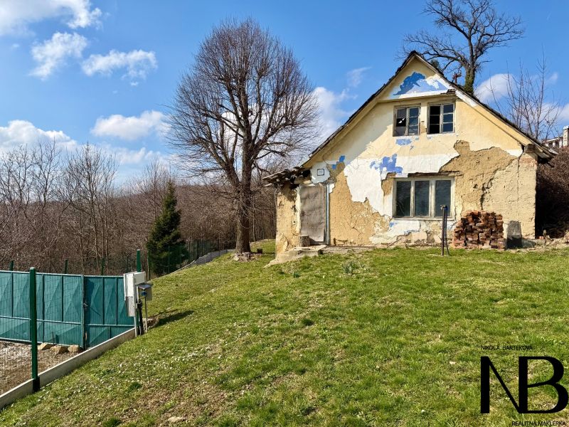 Ein älteres Haus auf einem Grundstück in Lubina, umgeben von Natur und Bäumen.