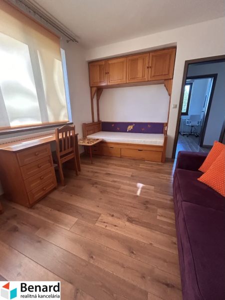 Ein Zimmer in einer 3-Zimmer-Wohnung mit Holzelementen, Schränken und einem Sofa.