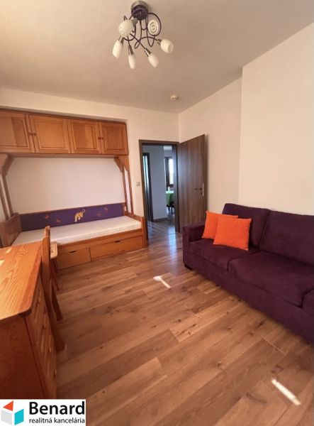 Ein Zimmer in einer 3-Zimmer-Wohnung mit einem Holzboden und einem regnerischen Ausblick aus dem Fenster.
