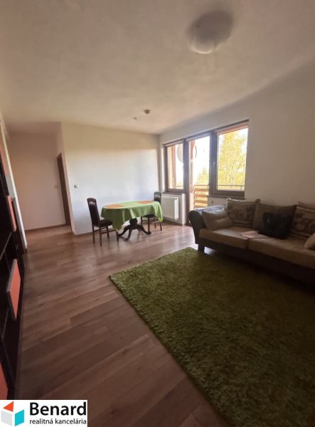 Wohnzimmer einer 3-Zimmer-Wohnung mit Holzboden, Esstisch und Sofa.
