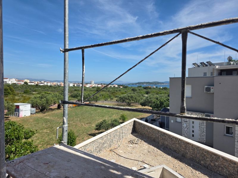 Der Ausblick aus der 3-Zimmer-Wohnung in TRIBUNJ zeigt eine Baustelle und ein Panorama mit Meer.