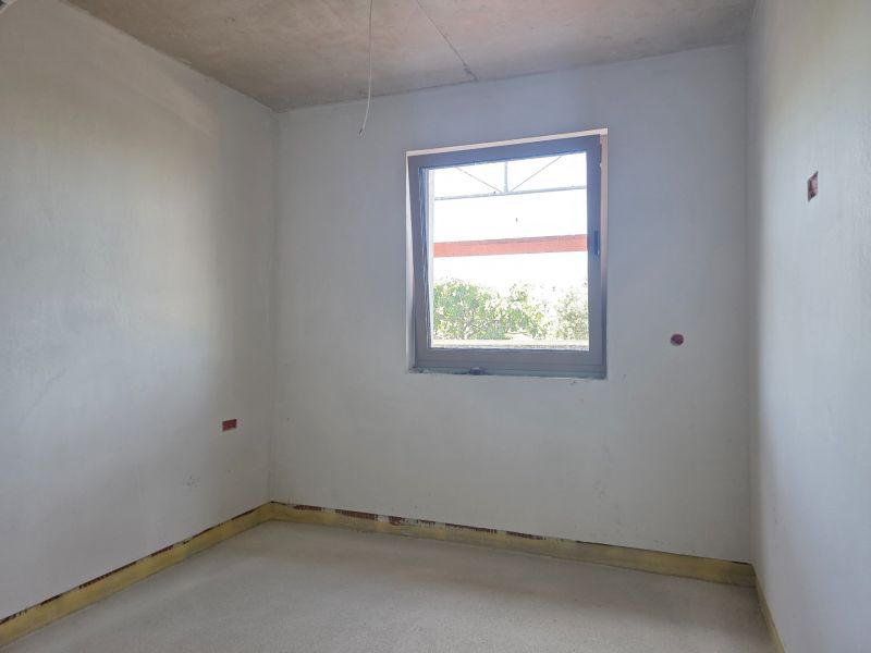 Ein leerer Raum mit einem Fenster in einer 3-Zimmer-Wohnung, bereit für weitere Anpassungen.