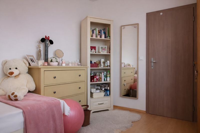 Kinderzimmer mit Schrank, Spiegel, großem Plüschbären und Boden mit Holzdekor.