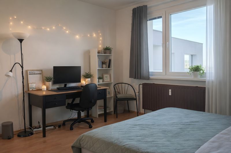 Schlafzimmer mit Tisch, Computer, Stuhl und Regal in einer 4-Zimmer-Wohnung. Boden mit Holzdekor.