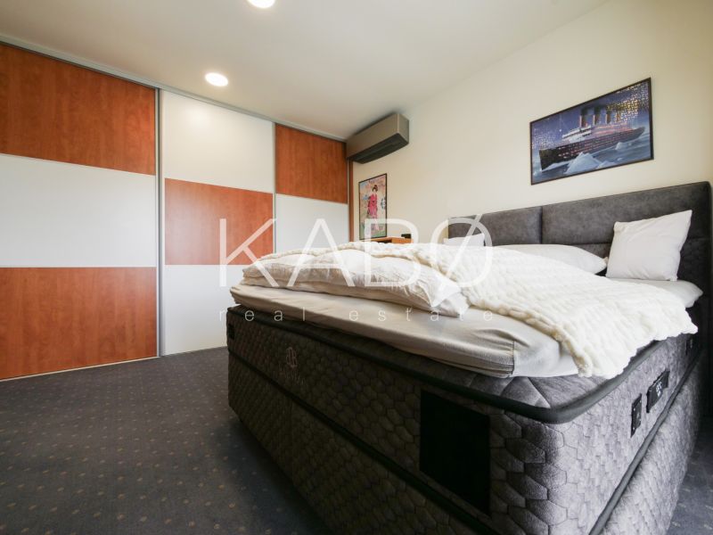 Schlafzimmer im Einfamilienhaus mit großem Bett und Schiebetürenschrank.