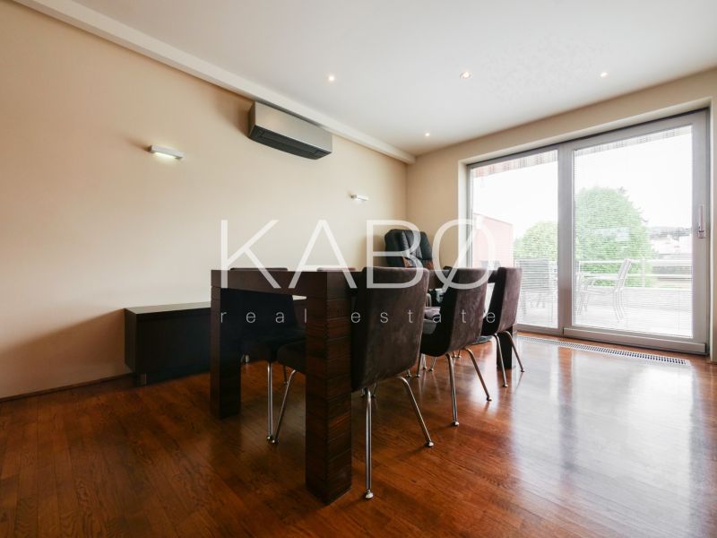 Esszimmer in einem Einfamilienhaus mit Holzboden und Glastüren zur Terrasse.