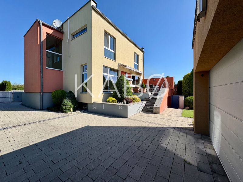 Ein Einfamilienhaus in Partizánske mit Garten, Terrasse und Garage auf einem befestigten Hof.