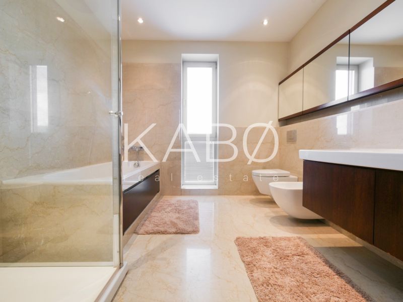 Ein Badezimmer im Einfamilienhaus mit Badewanne, Waschbecken und Spiegelschränken.