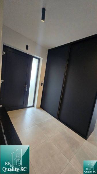 Eingangsflur in einem Einfamilienhaus mit dunkler Tür und großem Schrank.