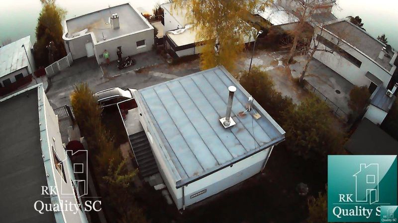 Hütte in Senec am SONNENSEE SÜD, mit Flachdach, umgebenden Bäumen und einer Straße.