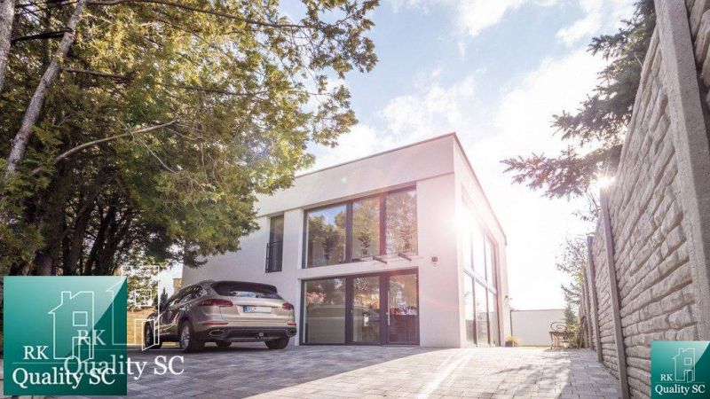 Einfamilienhaus am Sonnensee Süd in Senec mit angrenzendem Parkplatz und Grünfläche.