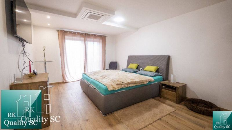 Ein Schlafzimmer in einem Einfamilienhaus mit einem Holzboden und minimalistischer Einrichtung.