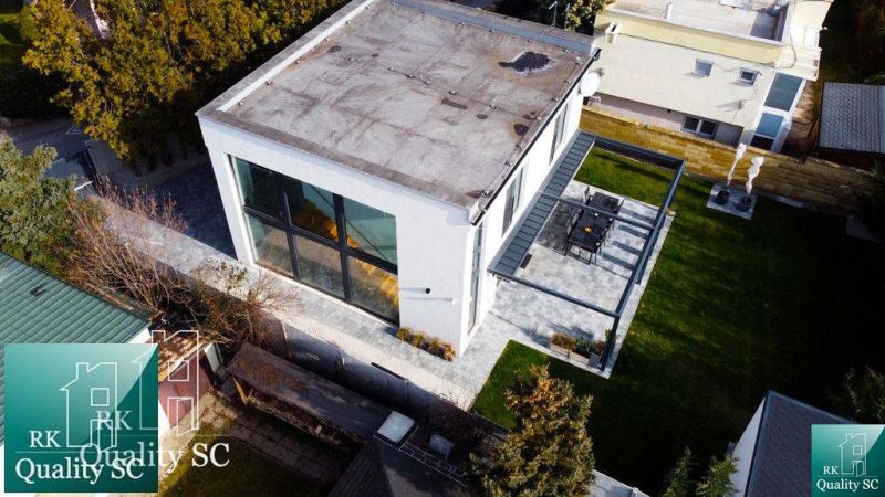 Ein Einfamilienhaus an den Sonnenseen Süd in Senec mit großen Fenstern und einer Terrasse.