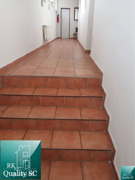 Flur mit Keramikfliesen und Treppe in einem Einfamilienhaus.