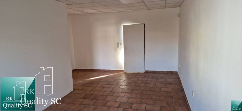 Ein Zimmer in einem Einfamilienhaus mit Fliesenboden und weißen Wänden.
