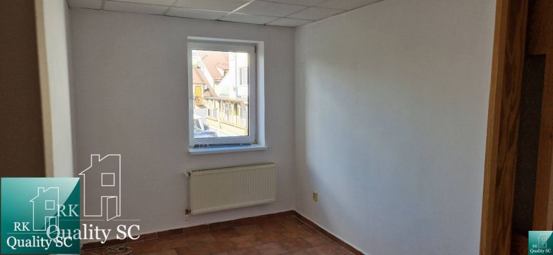 Weiße Wand mit Fenster, Heizkörper und Fliesen in einem Einfamilienhaus.
