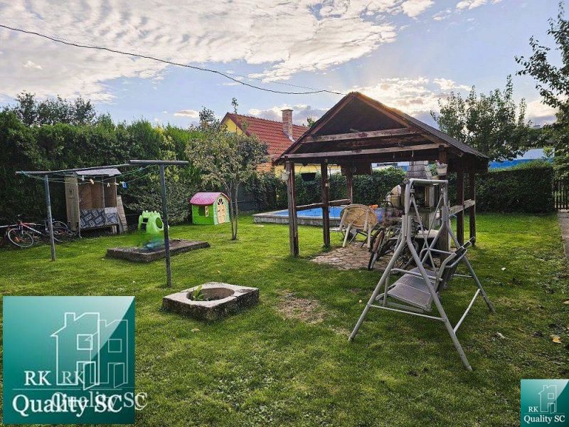 Ein Einfamilienhaus in der Stadt Tureň mit einem Gartenpavillon, einer Schaukel und einem Kinderspielplatz.