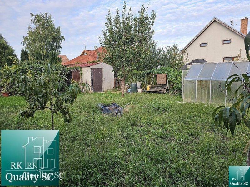 Ein Garten mit Obstbäumen und einem Gewächshaus bei einem Einfamilienhaus in der Straße in Tureň.