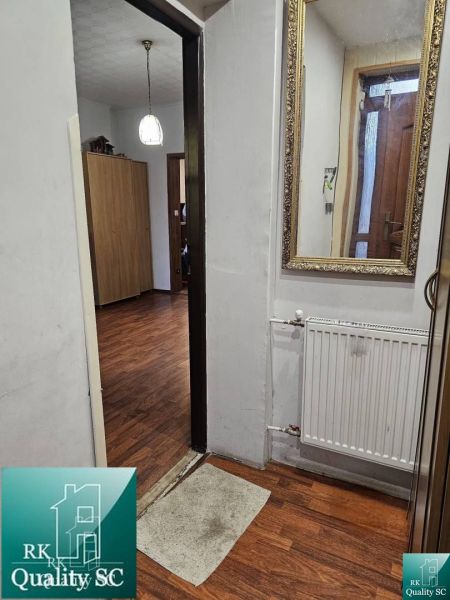 Innenraum eines Einfamilienhauses mit Holzboden, Spiegel und Heizkörper.