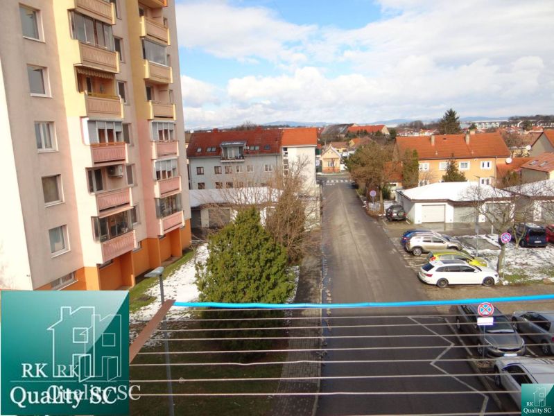 Blick aus einer Einzimmerwohnung am Platz des 1. Mai in Senec, Straße und Parkplatz.