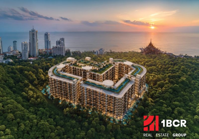 Wohnungsbau in Pattaya am Meer, umgeben von Grünflächen und hohen Gebäuden.