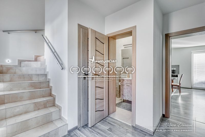 Eine Treppe mit Marmorkacheln und ein Boden mit Holzdekor in einem Einfamilienhaus.