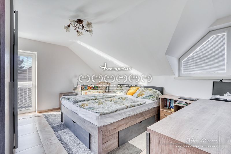 Helles Dachbodenschlafzimmer mit bequemem Bett und Aussicht, Einfamilienhaus.