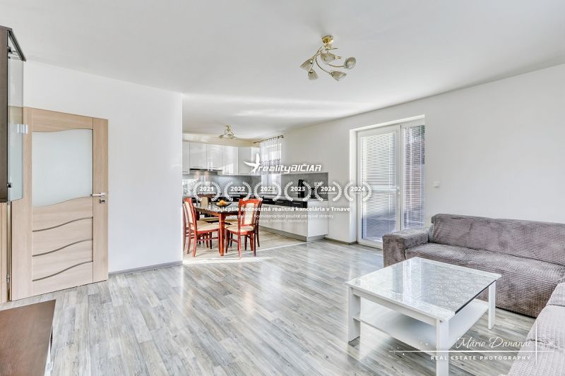 Innenraum eines Einfamilienhauses mit offener Küche und Wohnzimmer, Boden mit Holzdekor.