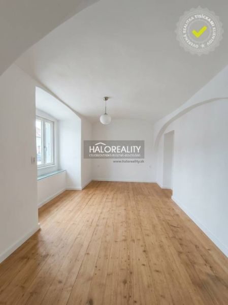 Helles Zimmer mit gewölbter Decke und Holzboden in einer 3-Zimmer-Wohnung.