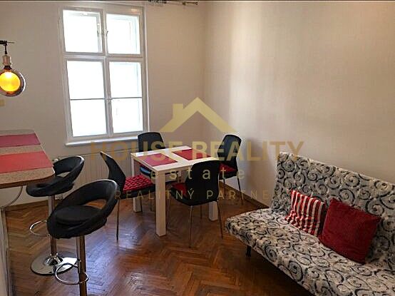 Essbereich in einer 2-Zimmer-Wohnung mit Holzboden und stilvollen Sitzgelegenheiten.