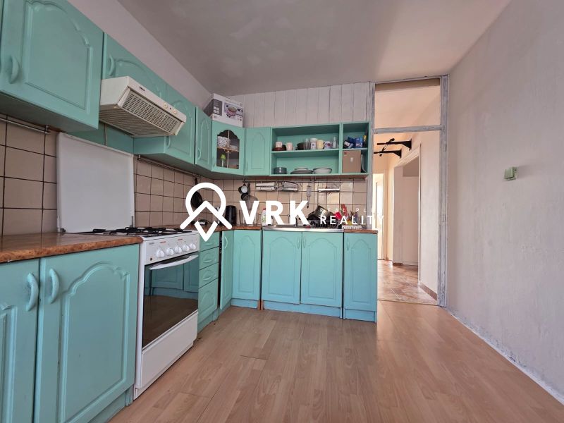 Küche mit grüner Küchenzeile und Boden in Holzoptik in einer 4-Zimmer-Wohnung.