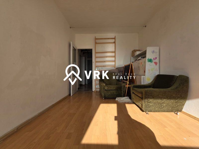 Ein Zimmer in einer 4-Zimmer-Wohnung mit einem Holzboden und grünen Sesseln.