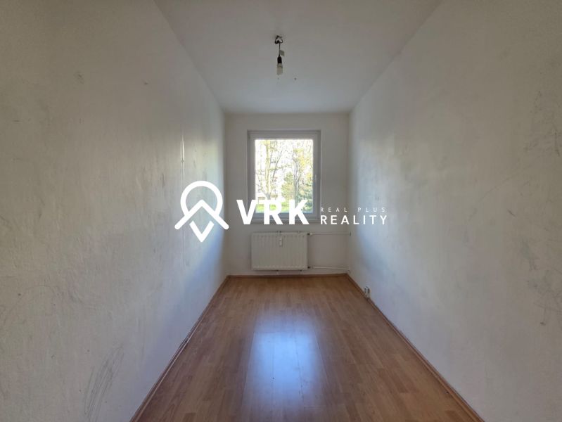Ein leerer Raum mit Holzboden in einer 4-Zimmer-Wohnung.