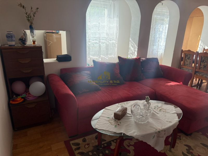 Rotes Sofa in einer Hütte mit Holzboden und Glastisch.