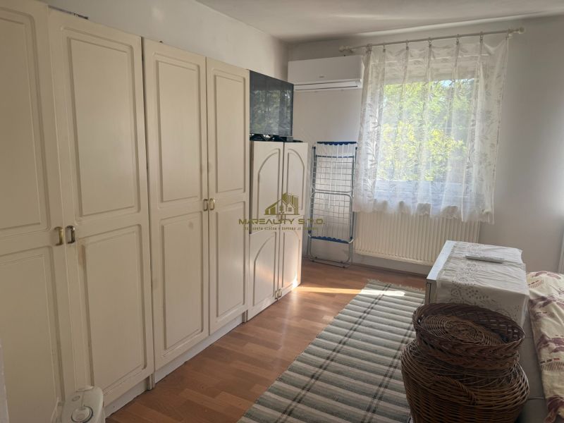Ein Zimmer mit weißen Schränken, einem Fenster und einem Holzboden in einer Hütte.