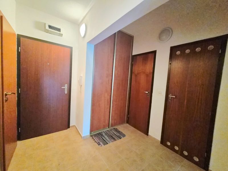 Diele in einer 2-Zimmer-Wohnung mit Holztüren und Fliesenboden.