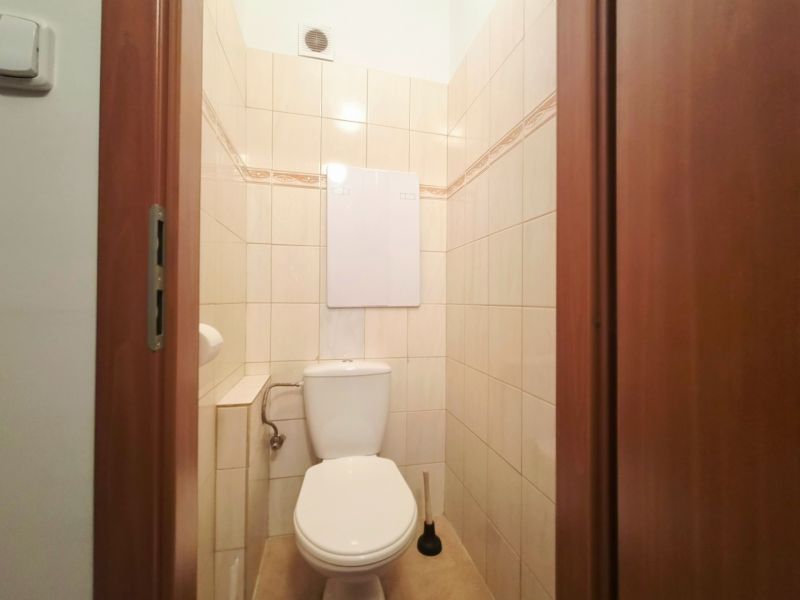 Badezimmer in einer 2-Zimmer-Wohnung mit Fliesen und Toilette.