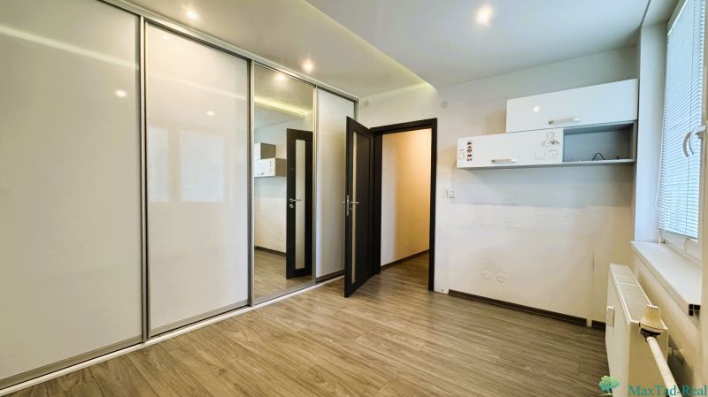 Ein Zimmer mit einem Einbauschrank und einem Boden in Holzoptik in einer 4-Zimmer-Wohnung.