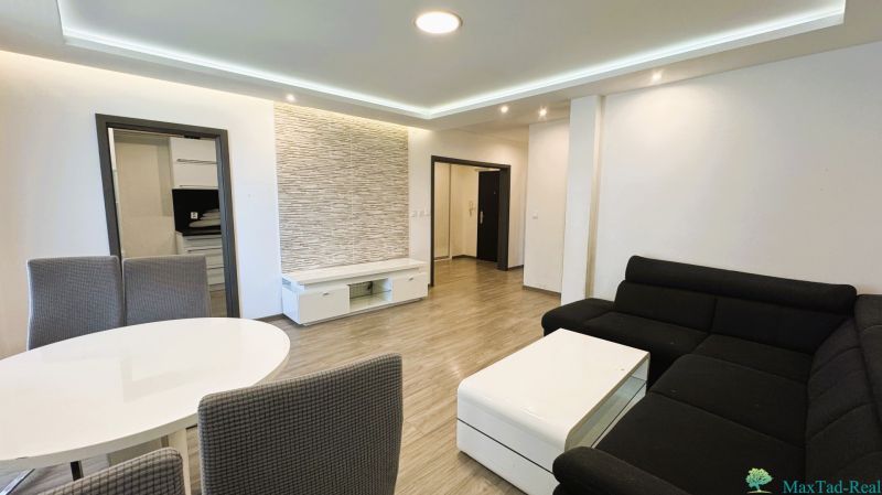 Wohnzimmer mit Sofa, Esstisch und Holzboden in einer 4-Zimmer-Wohnung.