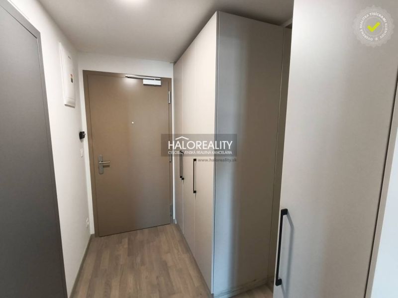 Ein Zimmer mit Holzboden und Balkontüren in einer Einzimmerwohnung.