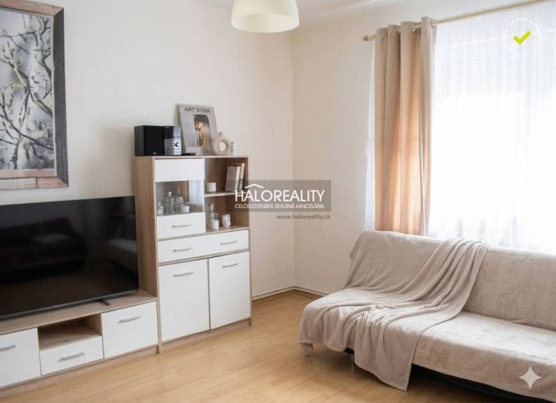 Wohnzimmer in einem Einfamilienhaus mit Holzboden und heller Couch.