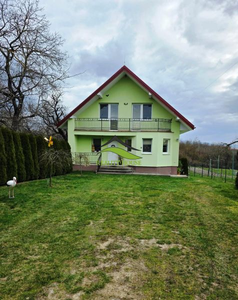Grünes Einfamilienhaus in Klokočov mit Veranda und gepflegtem Garten.
