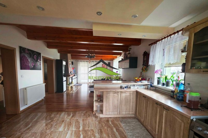 Küche mit Holzboden, Holzbalken und Dekorationen in einem Einfamilienhaus.