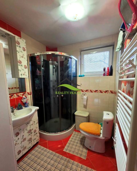 Badezimmer in einem Einfamilienhaus mit Toilette, Duschkabine und dekorativen Fliesen.