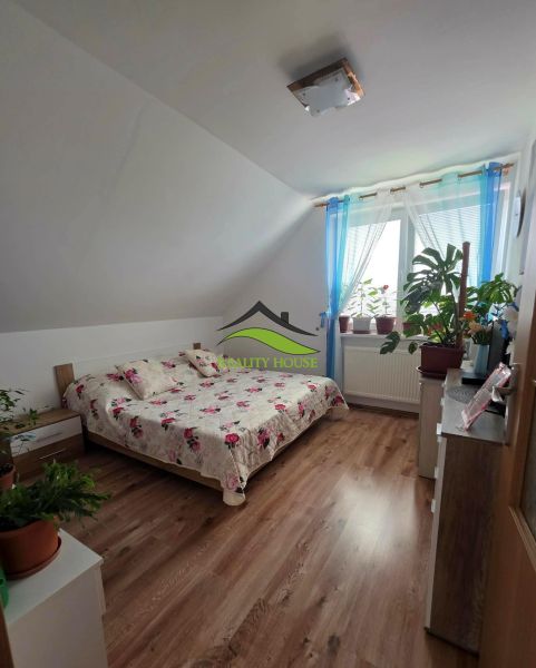 Schlafzimmer in einem Einfamilienhaus mit Holzboden und einem Bett mit einer Blumenüberdecke.