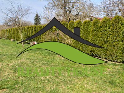 Der Garten des Einfamilienhauses in Klokočov mit gepflegtem Rasen und einer Hecke.