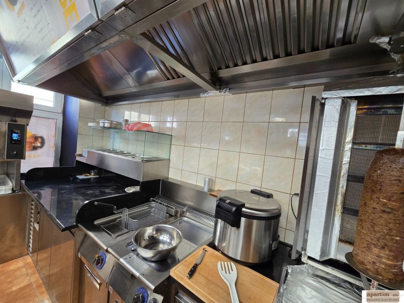 Küchenausstattung in Gastronomiebereichen mit Grill und Fritteuse zur Zubereitung von Speisen.