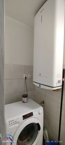 Waschmaschine und Boiler im Badezimmer einer 2-Zimmer-Wohnung mit praktischer Anordnung.